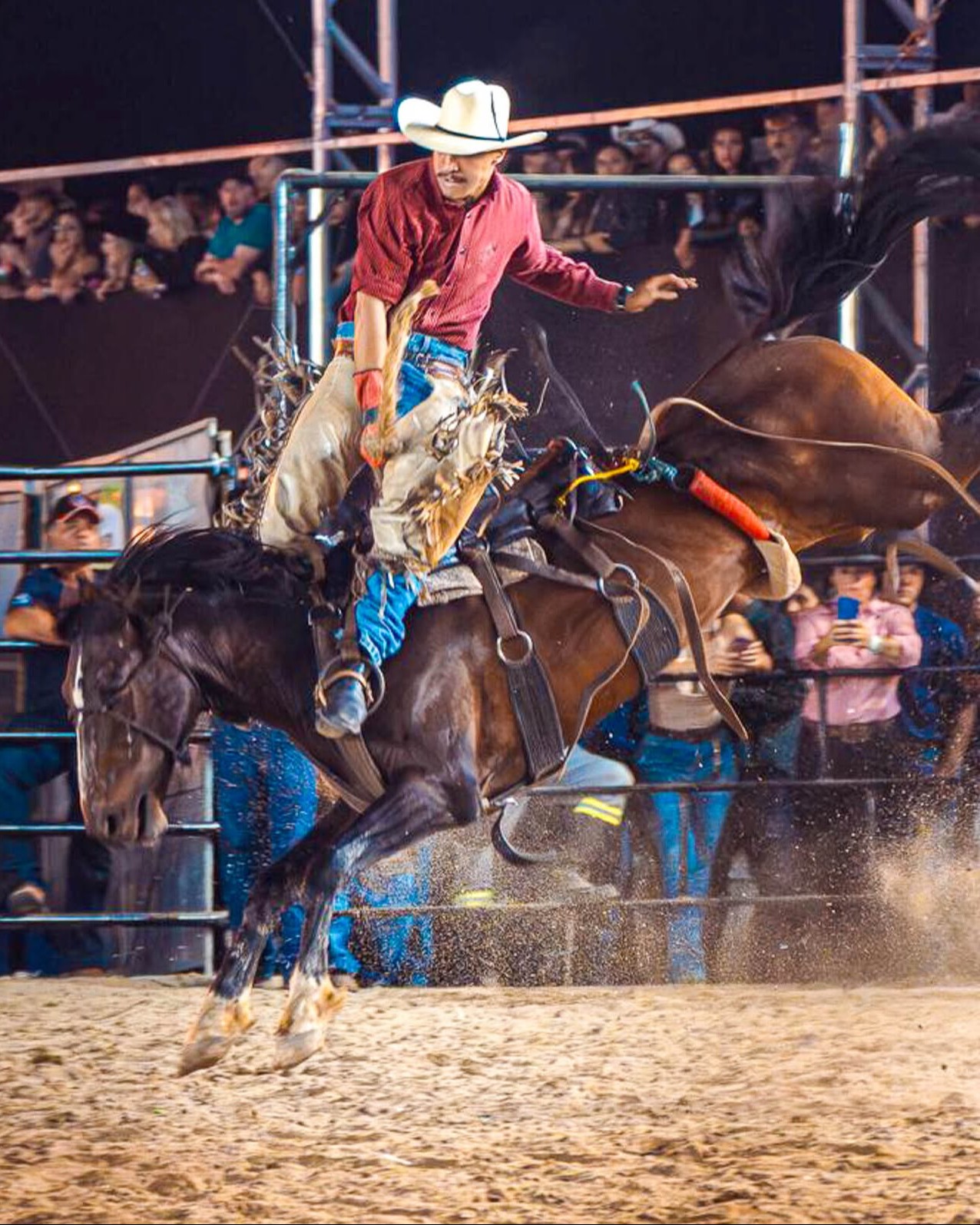 Momento da arena de rodeio durante o festival, com iluminação dramática